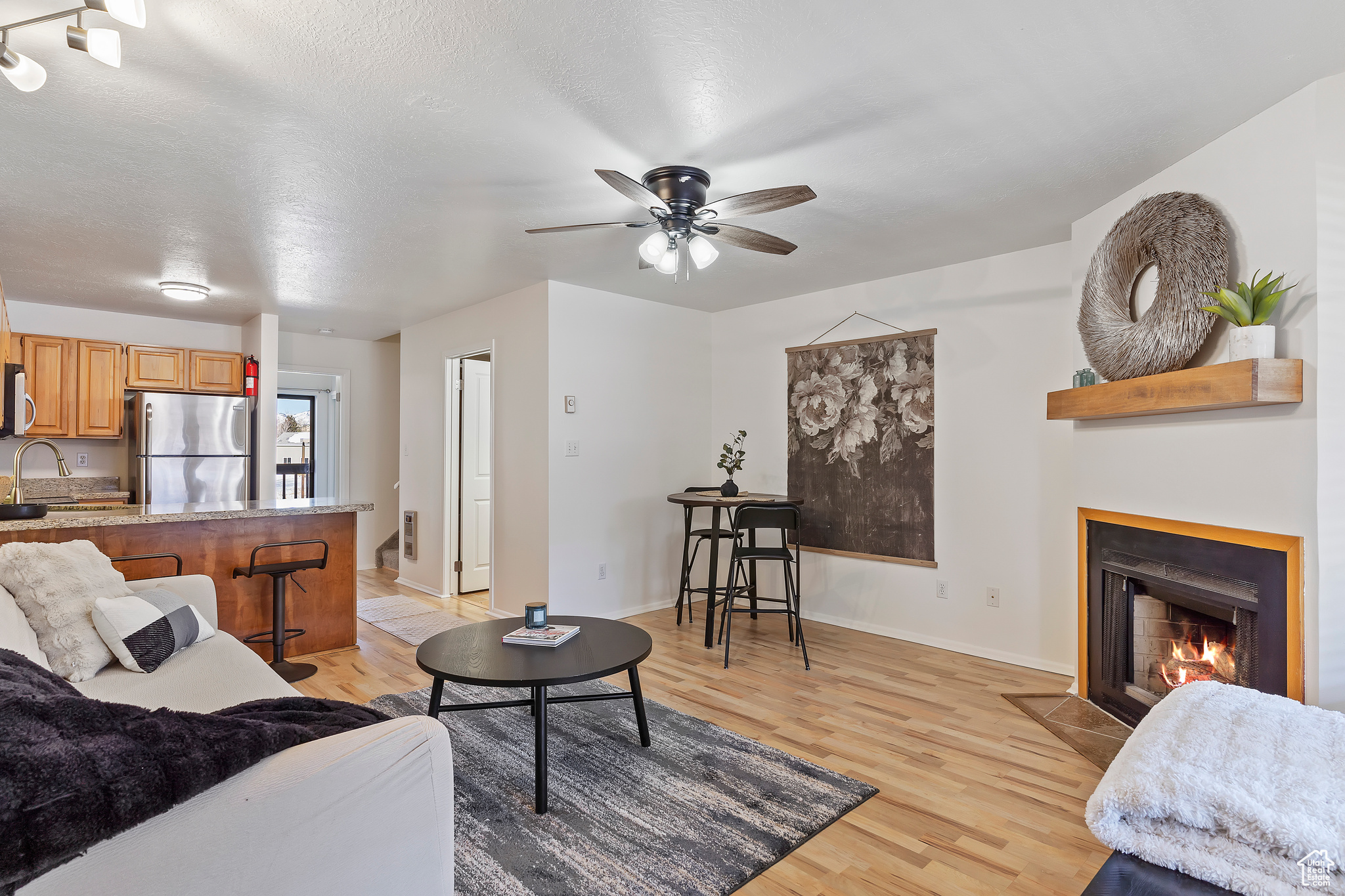 Living room featuring sink, ceiling fan, and light wood-type flooring