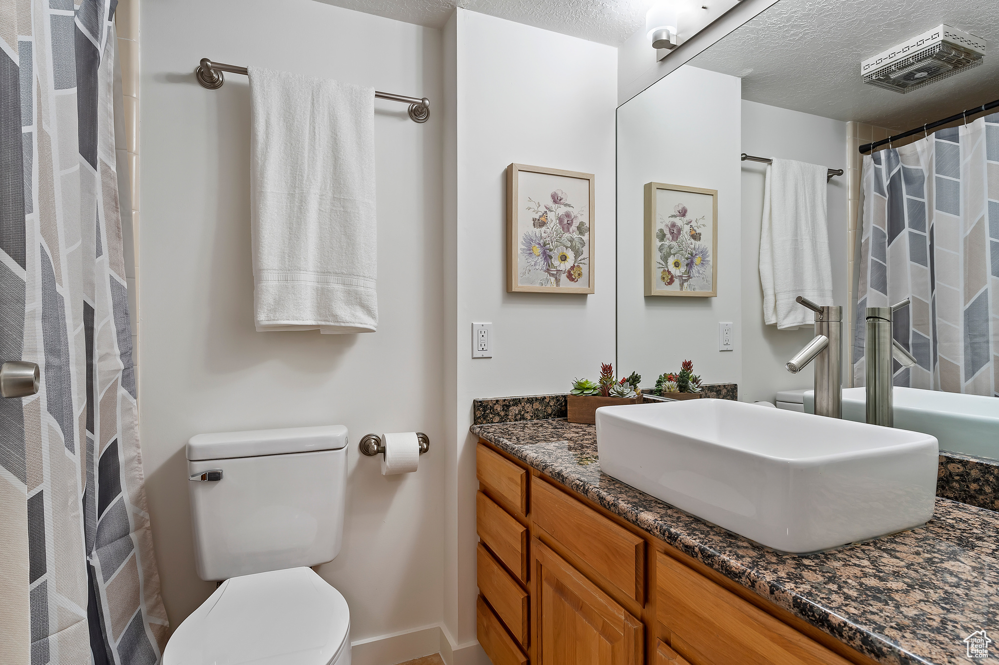 Bathroom with vanity, a textured ceiling, and toilet