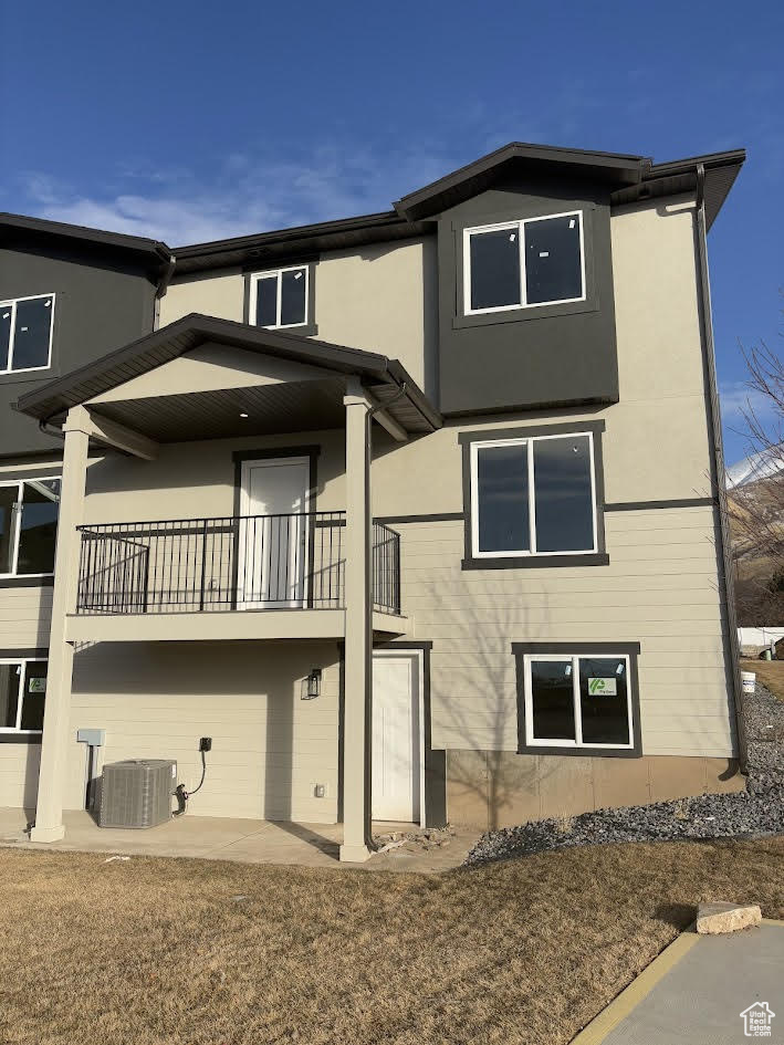 Back of house featuring central AC and a balcony