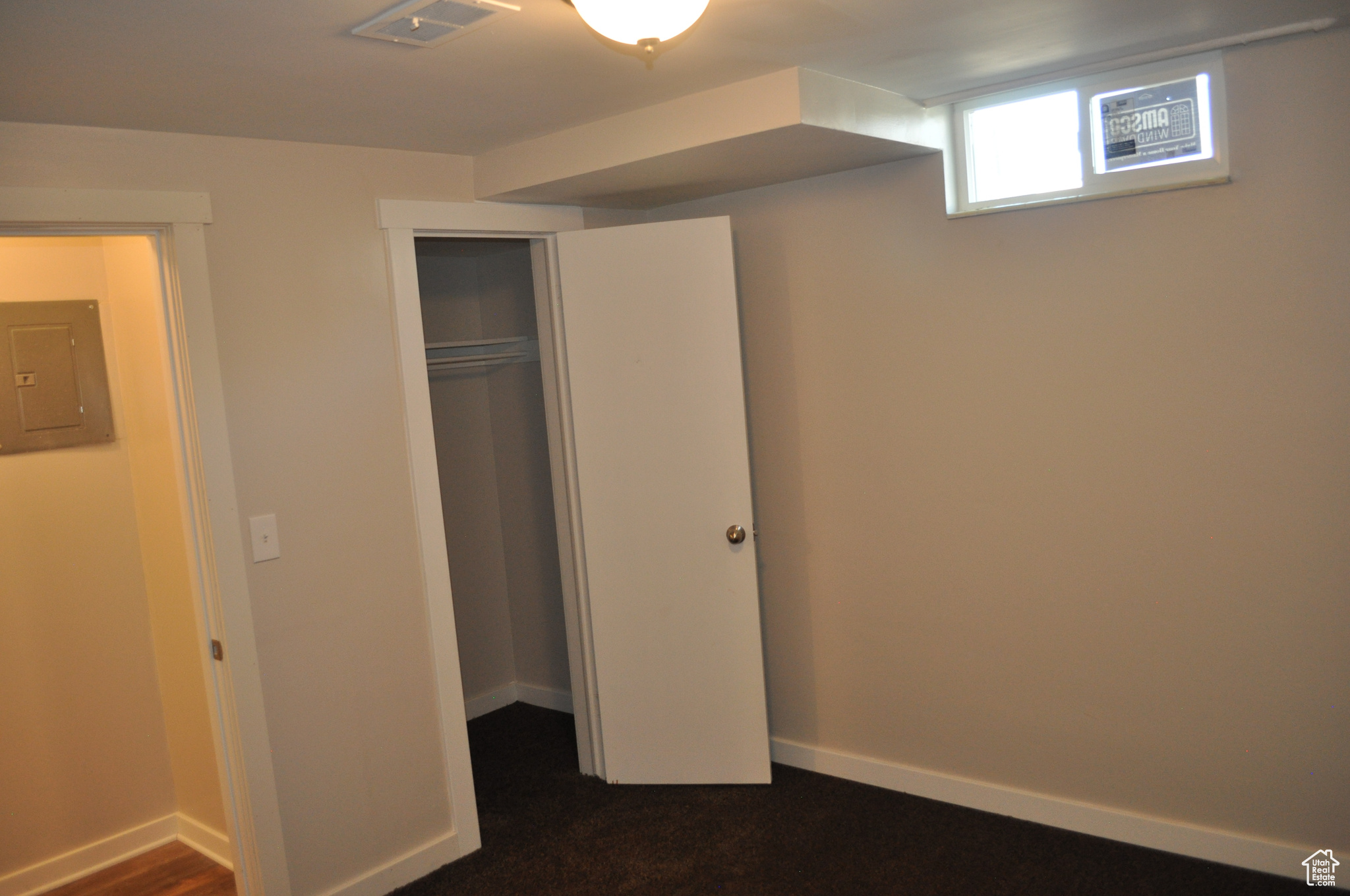 Unfurnished bedroom featuring electric panel and a closet