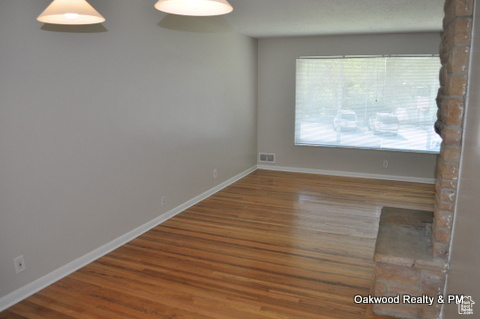 Empty room featuring dark hardwood / wood-style flooring