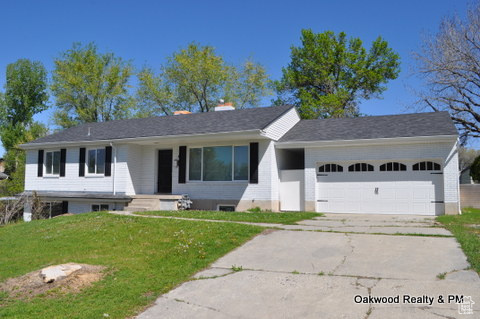 Ranch-style house with a garage and a front lawn