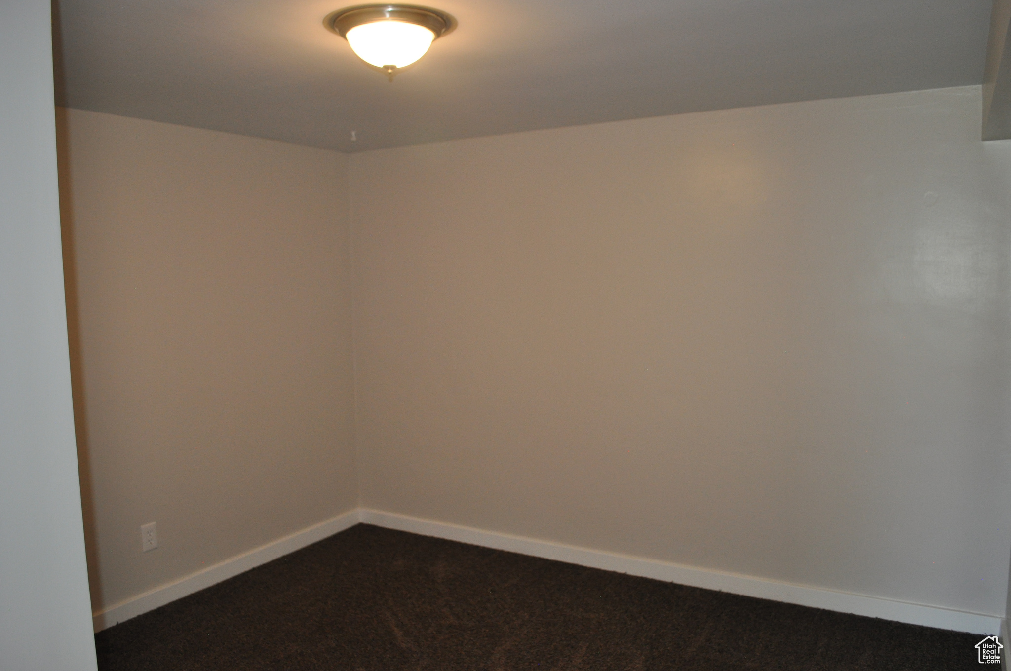 Empty room featuring dark carpet