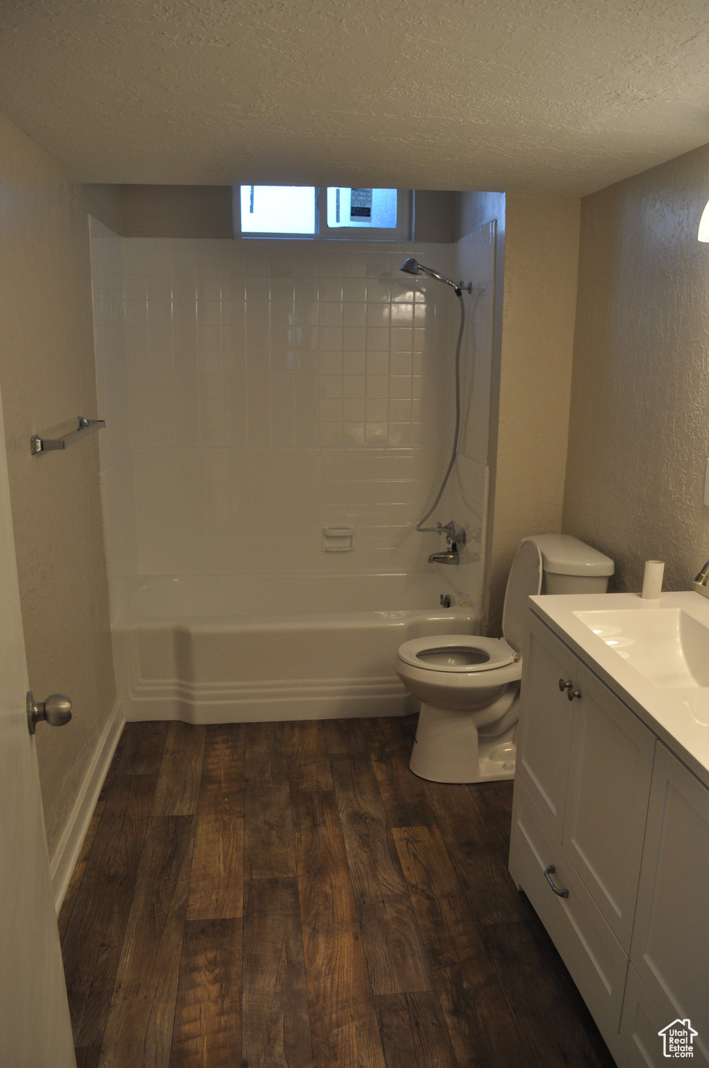 Full bathroom with toilet, tub / shower combination, a textured ceiling, vanity, and hardwood / wood-style flooring