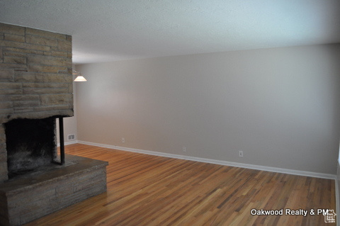 Unfurnished living room featuring hardwood / wood-style flooring, a fireplace, and a textured ceiling