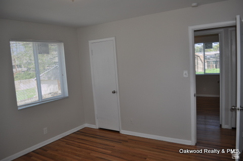 Unfurnished room with a healthy amount of sunlight and dark hardwood / wood-style flooring