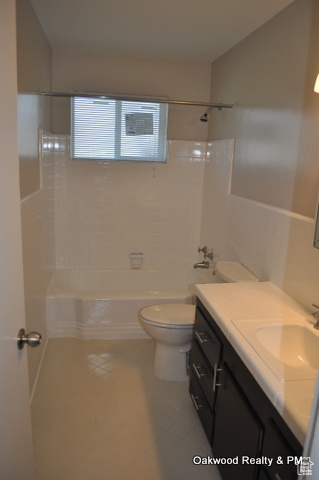 Full bathroom with shower / tub combination, tile walls, tile patterned flooring, vanity, and toilet