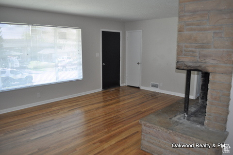 Unfurnished living room with plenty of natural light and dark hardwood / wood-style floors