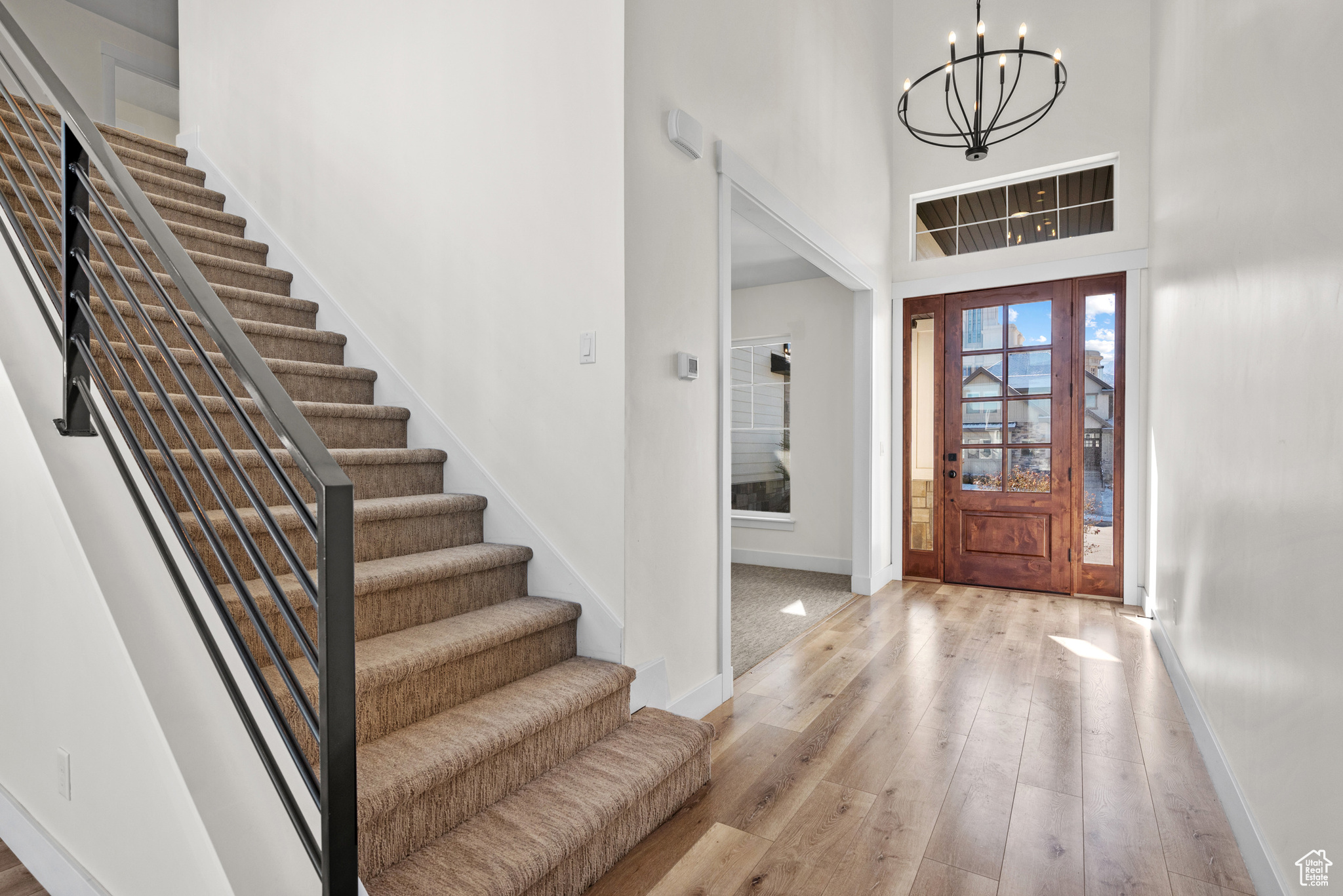 Entryway with a towering ceiling, a chandelier, and light hardwood / wood-style floors