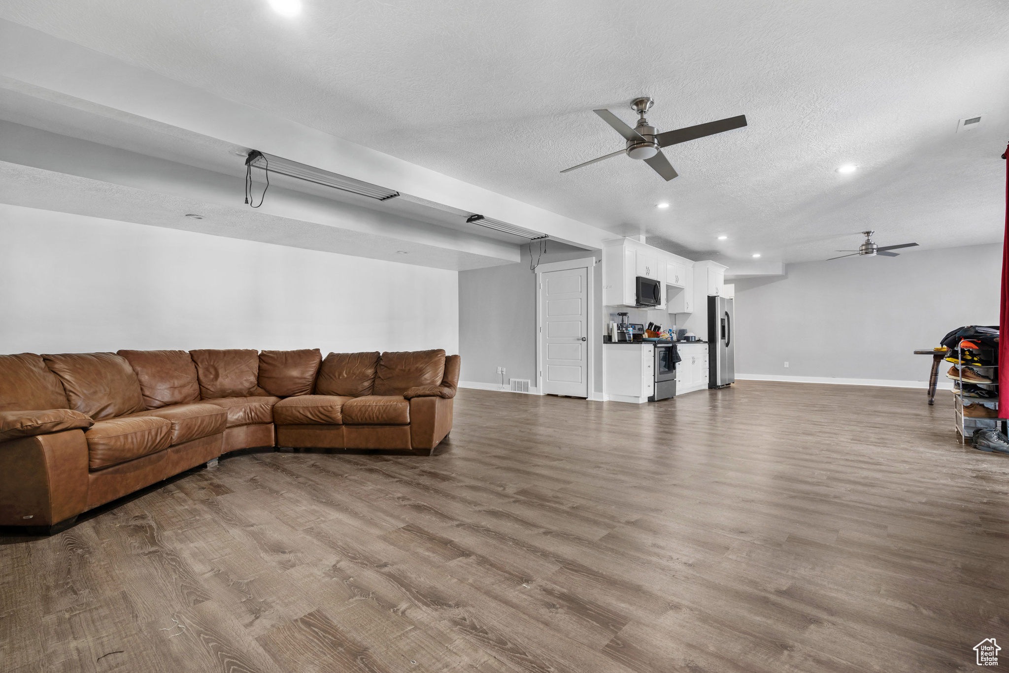 Living room featuring ceiling fan, light hardwood / wood-style floors, and a textured ceiling