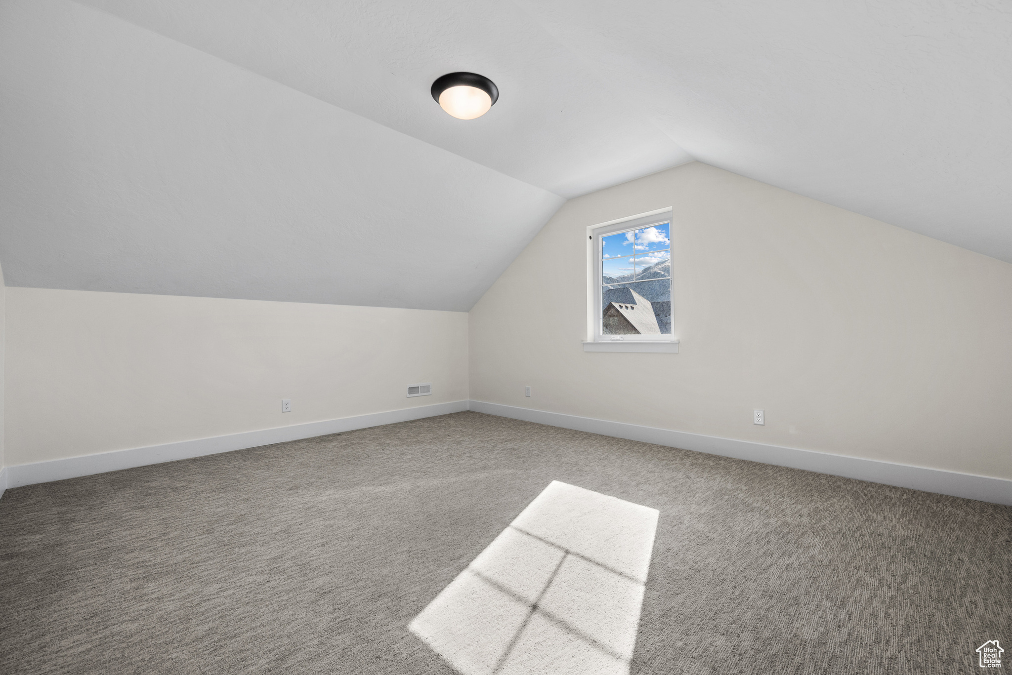 Bonus room with lofted ceiling and carpet flooring