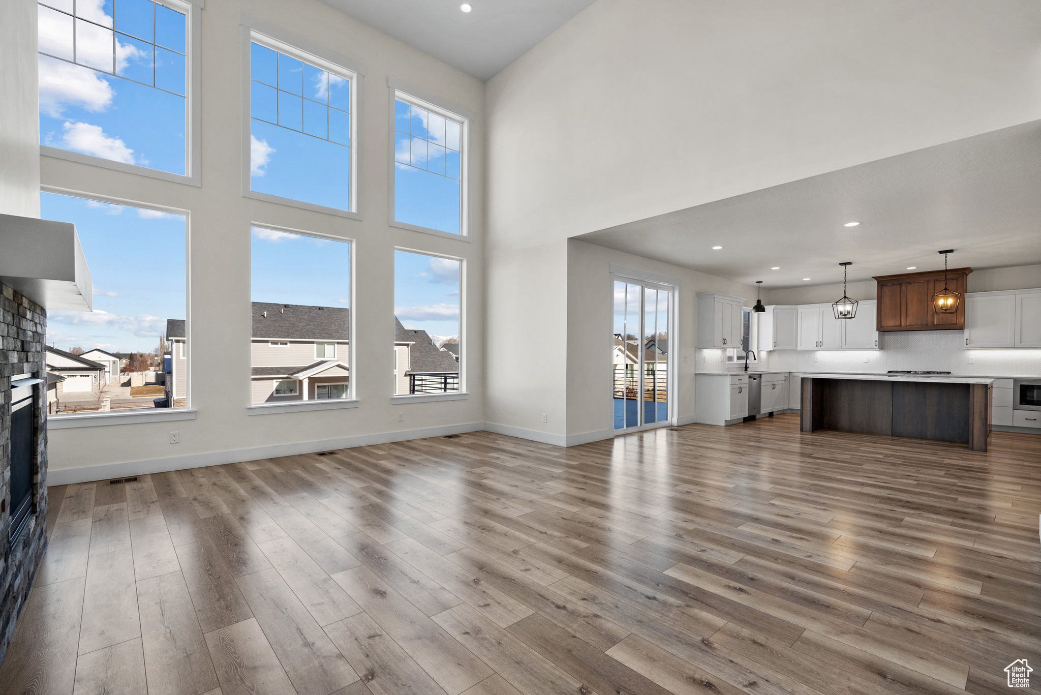 Unfurnished living room with hardwood / wood-style flooring, a towering ceiling, and sink