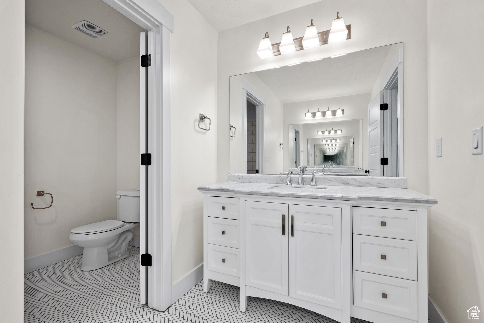 Bathroom featuring tile patterned floors, toilet, and vanity