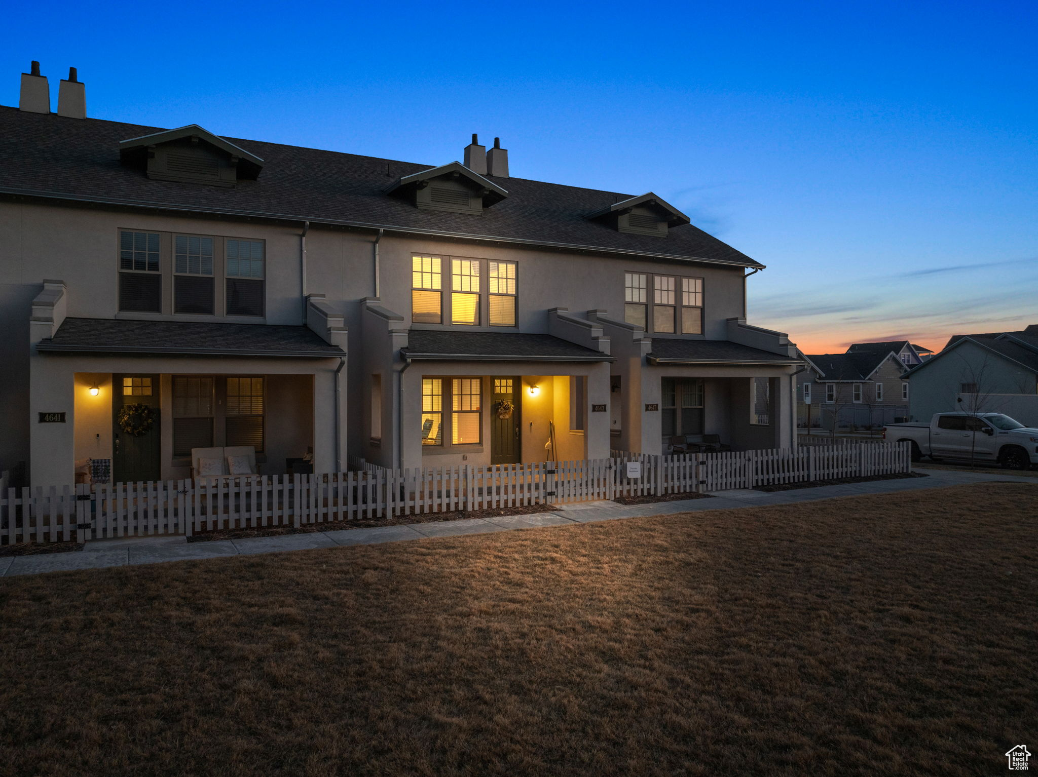 Back house at dusk featuring a yard