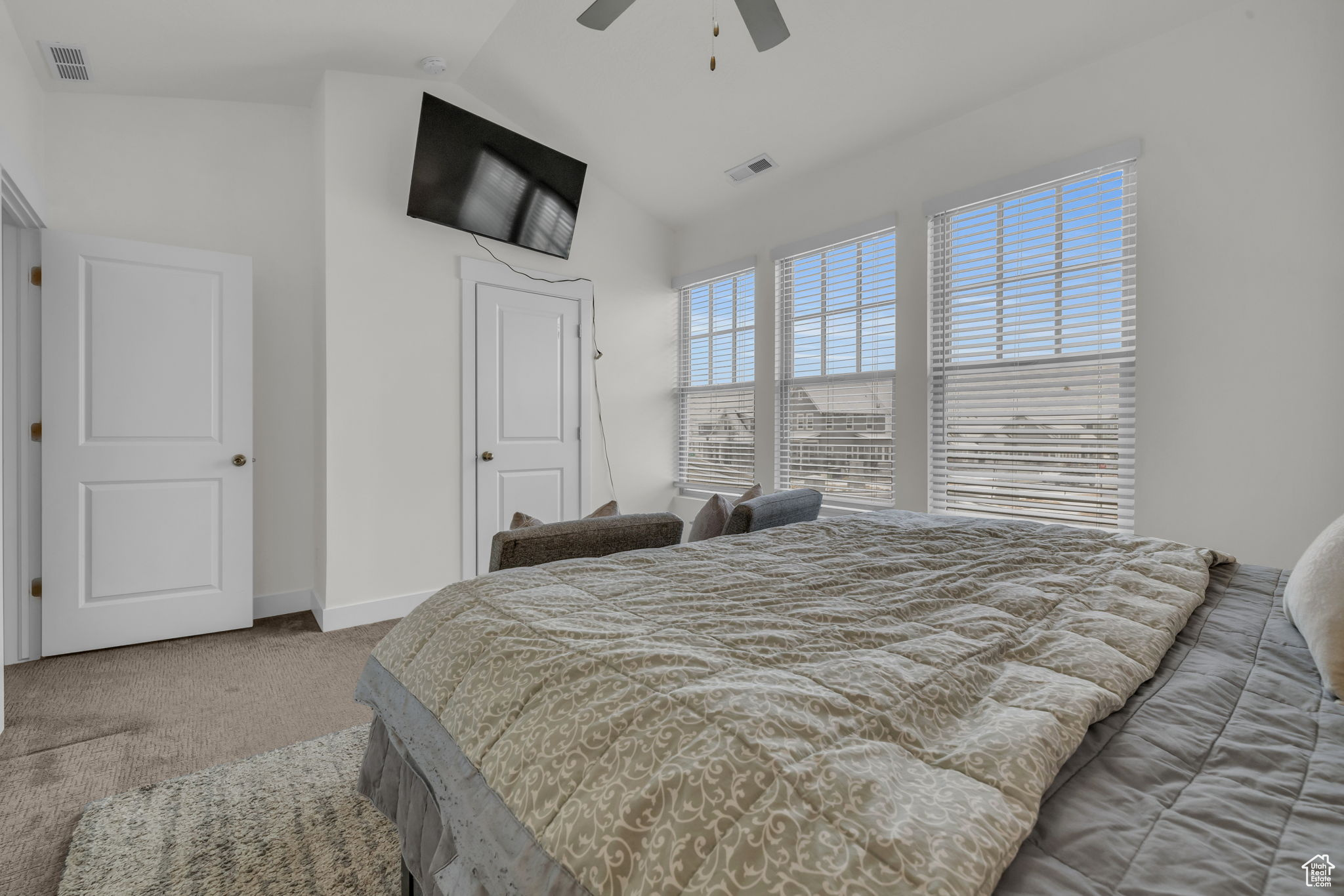 Bedroom with vaulted ceiling, carpet flooring, and ceiling fan