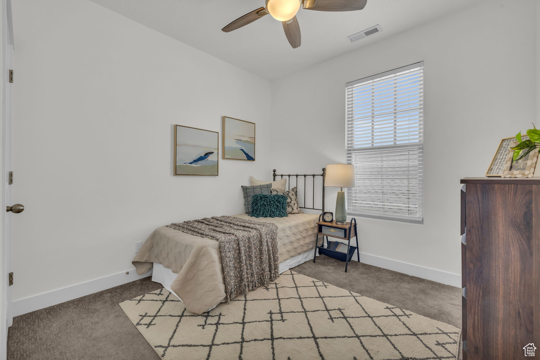 Bedroom with ceiling fan and light carpet