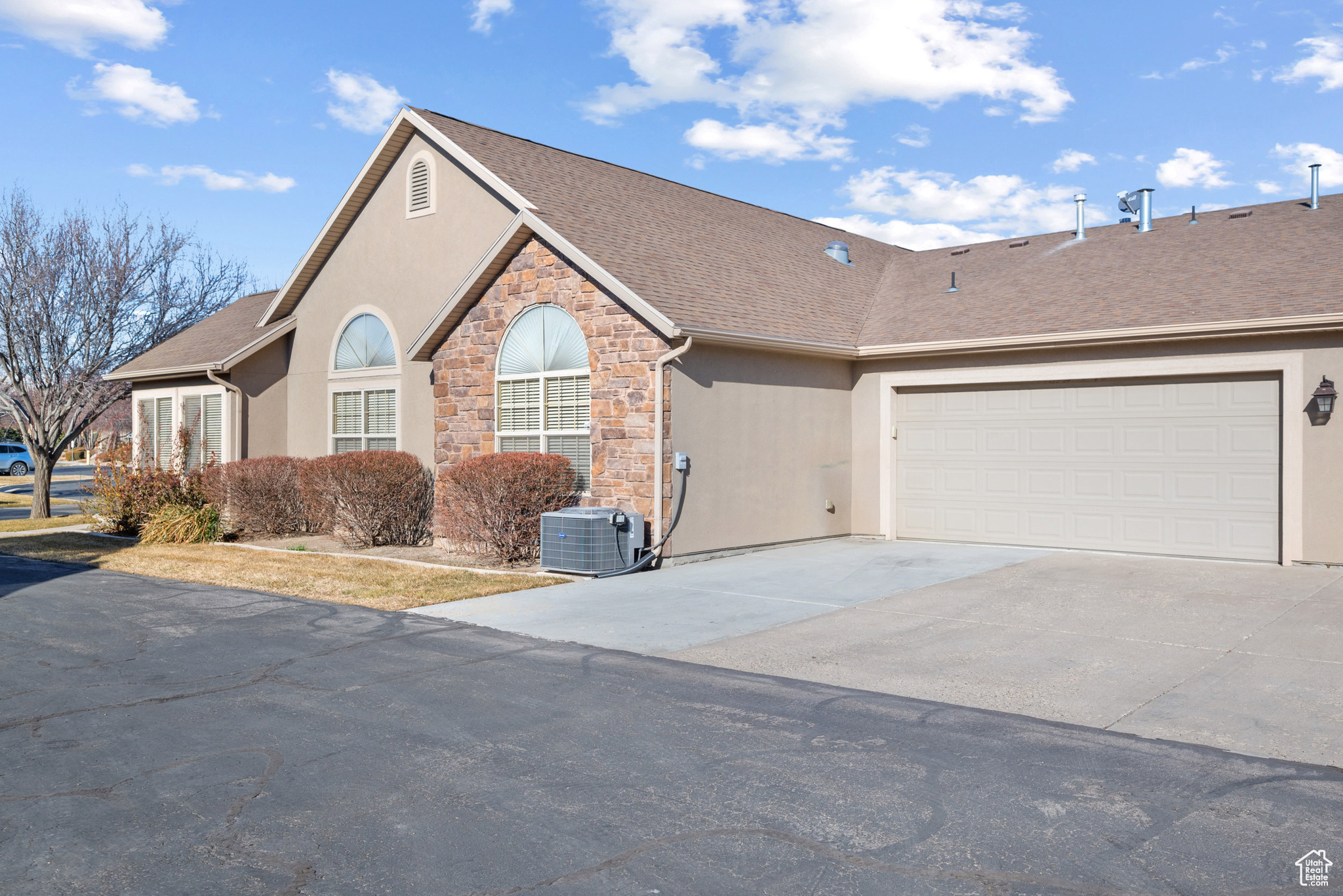 View of front of home featuring a garage and cooling unit