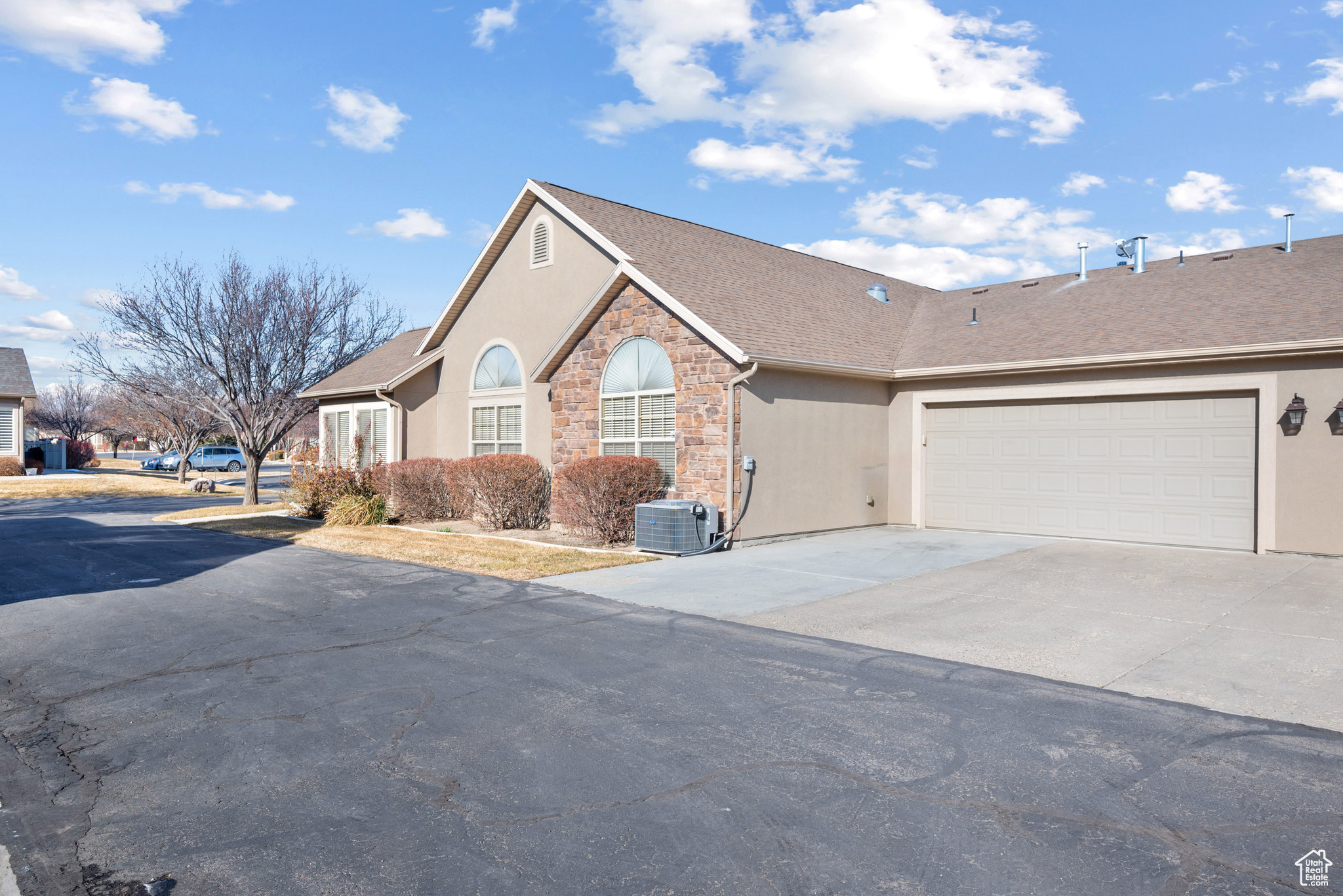 View of front of house featuring a garage and central AC