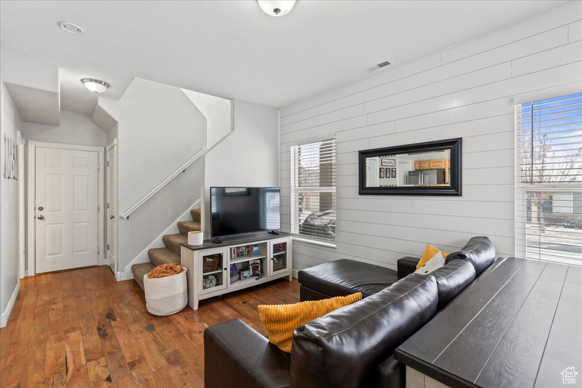 Living room with dark wood-type flooring and wooden walls