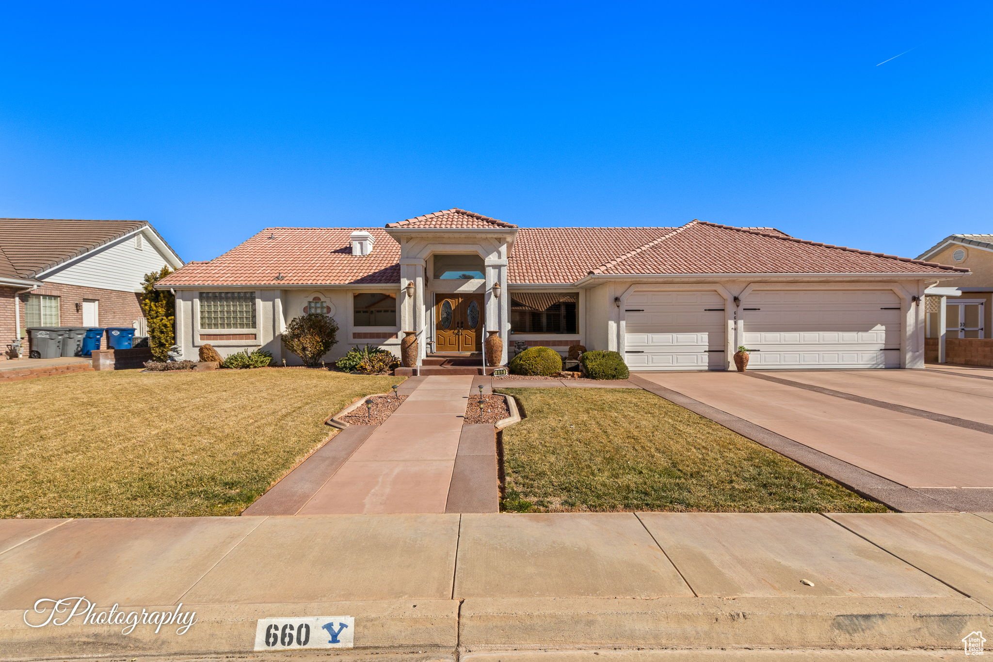 Mediterranean / spanish-style house featuring a garage and a front lawn