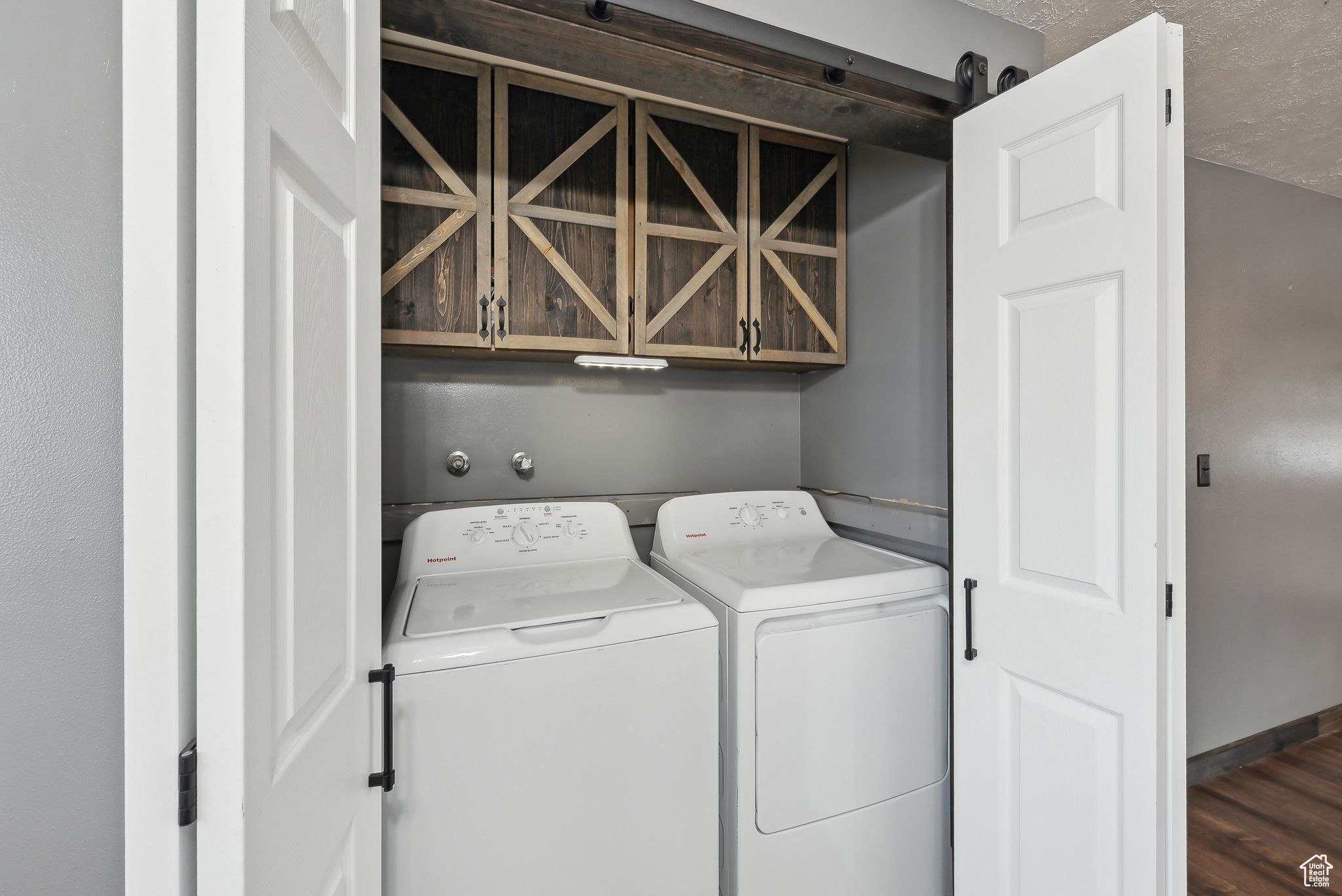 Laundry room with cabinets, dark hardwood / wood-style flooring, washer and dryer, and a textured ceiling