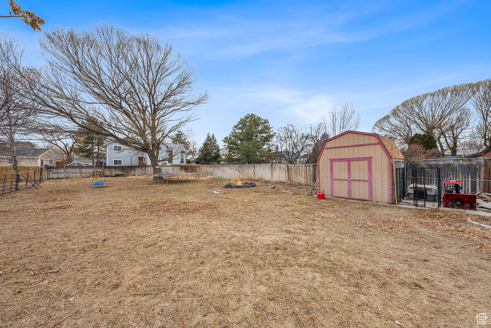 View of yard featuring a trampoline and a shed