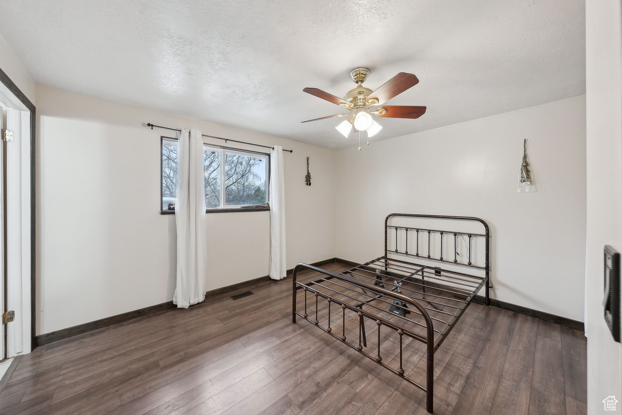 Bedroom featuring dark wood-type flooring and ceiling fan