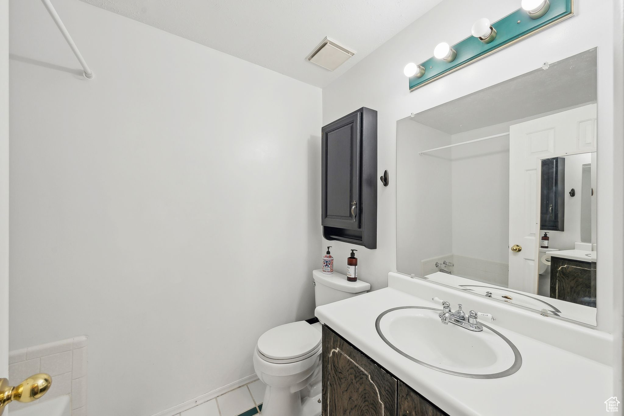 Bathroom with vanity, toilet, and tile patterned flooring