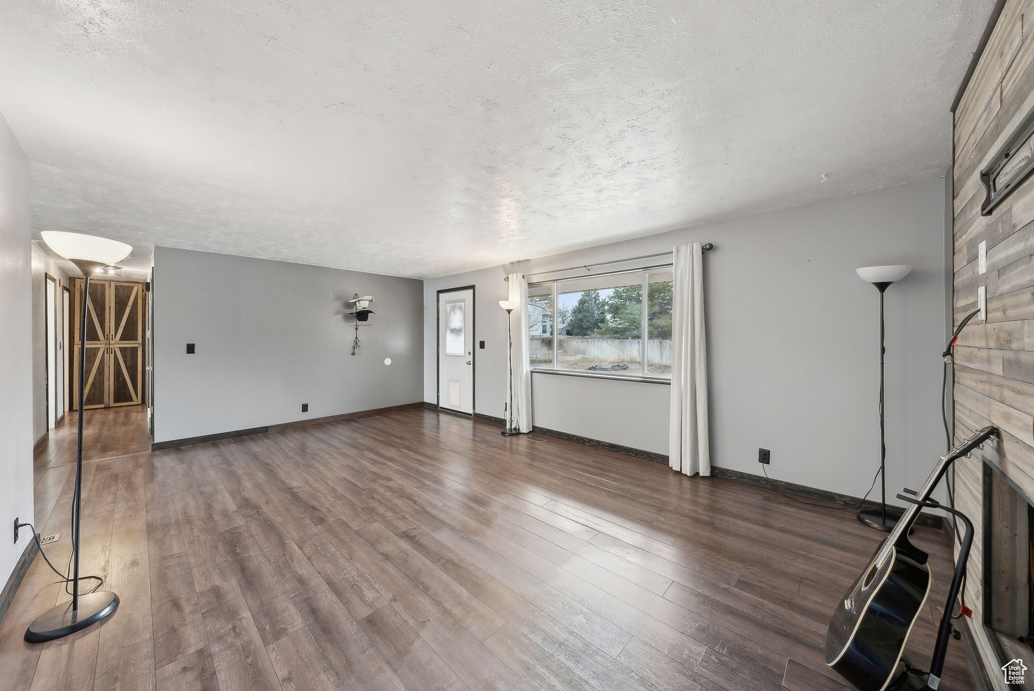 Unfurnished living room with a fireplace, dark hardwood / wood-style floors, and a textured ceiling