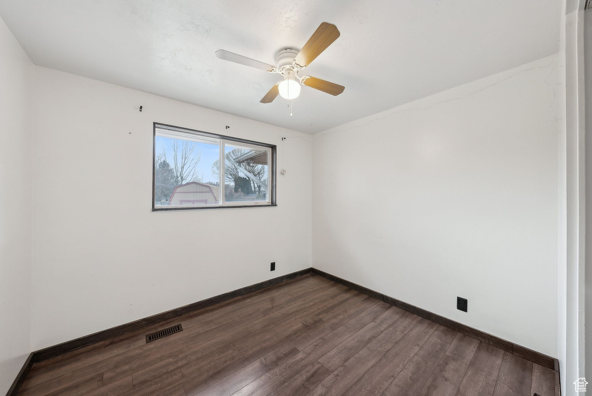 Spare room featuring dark hardwood / wood-style floors and ceiling fan