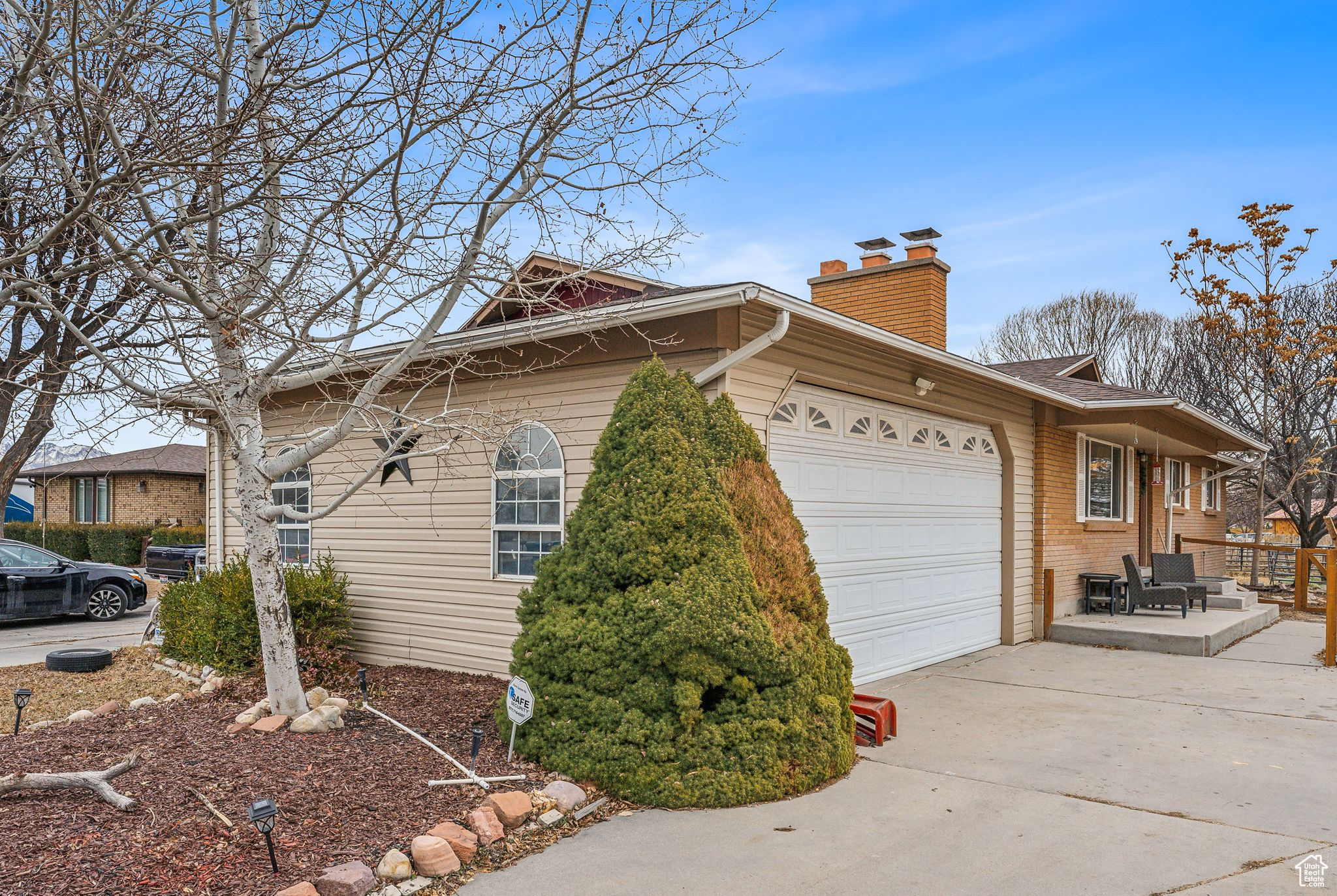 View of property exterior featuring a garage and a patio area