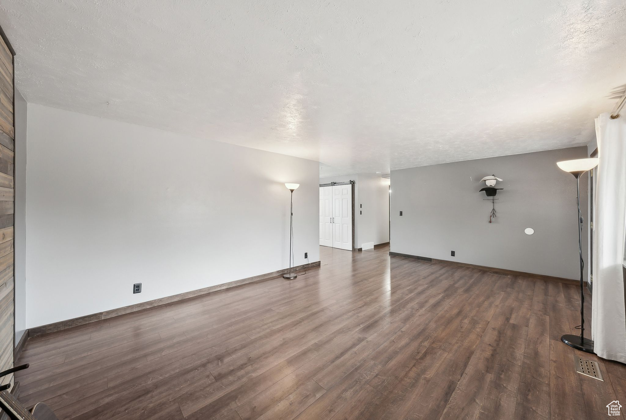 Spare room with dark hardwood / wood-style floors and a textured ceiling