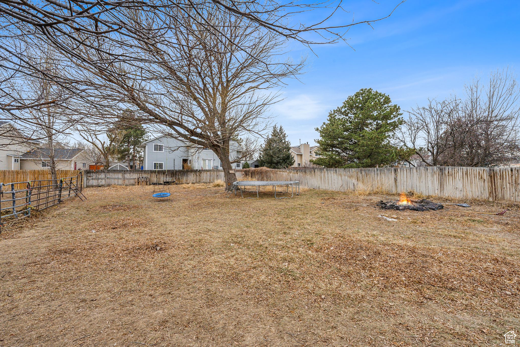 View of yard featuring a trampoline and an outdoor fire pit