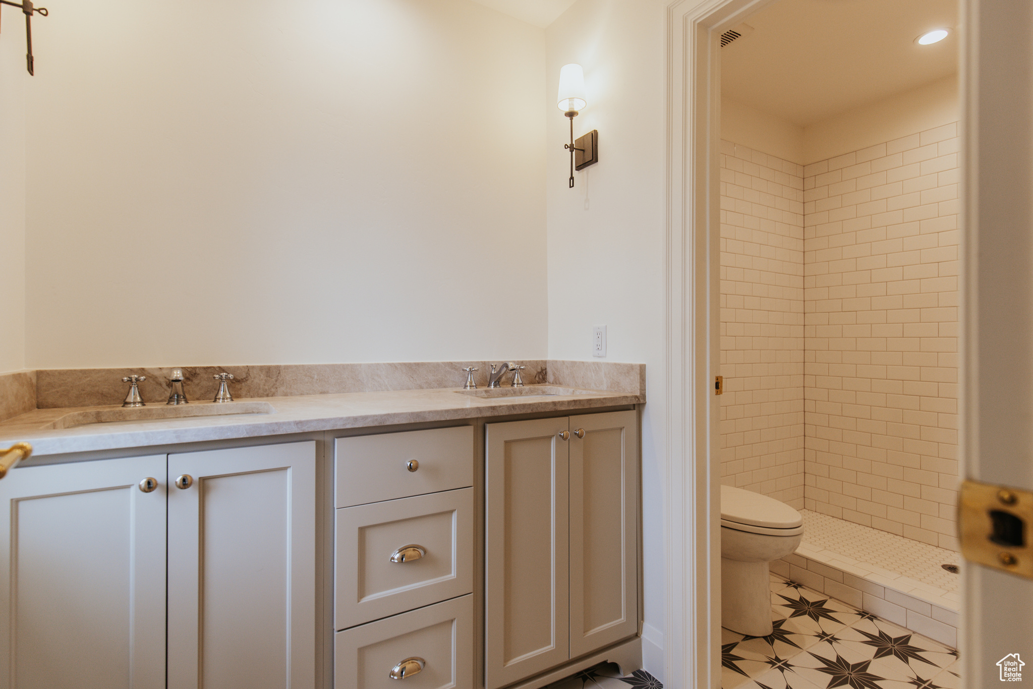 Bathroom featuring vanity, toilet, and tiled shower