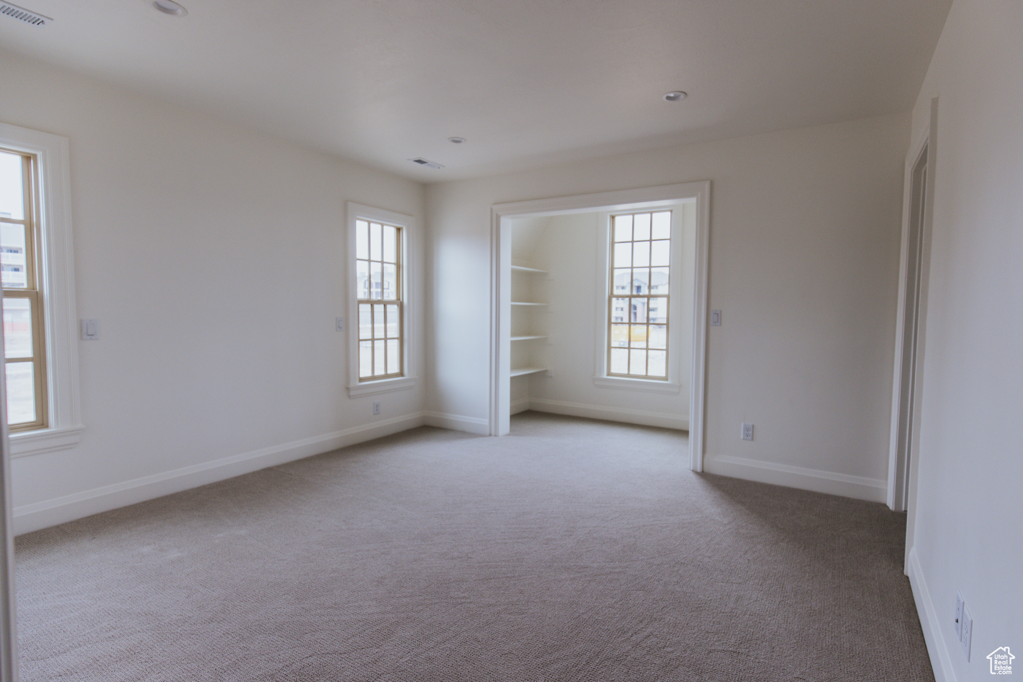 Spare room with plenty of natural light and light colored carpet