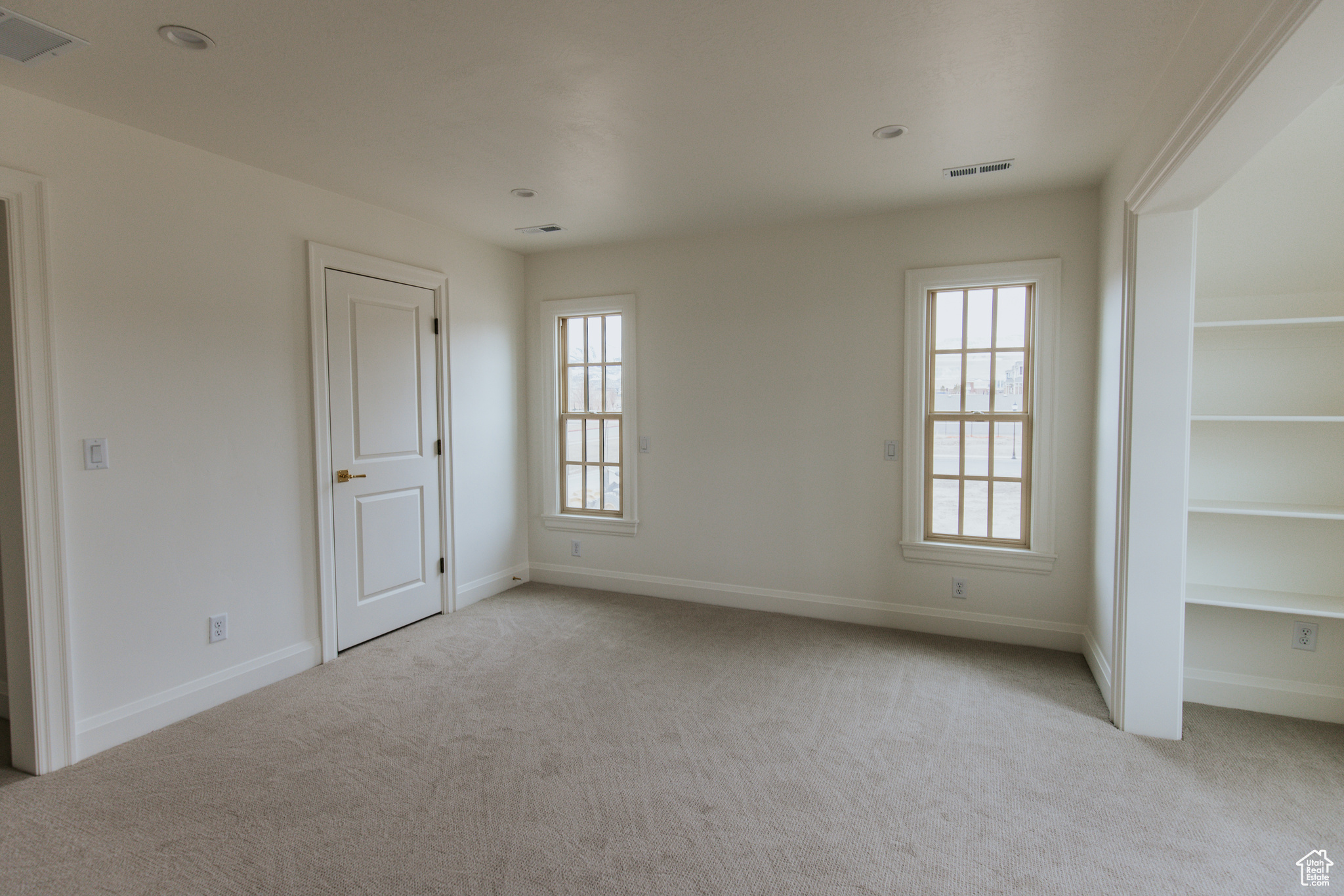 Unfurnished room with light carpet and a wealth of natural light