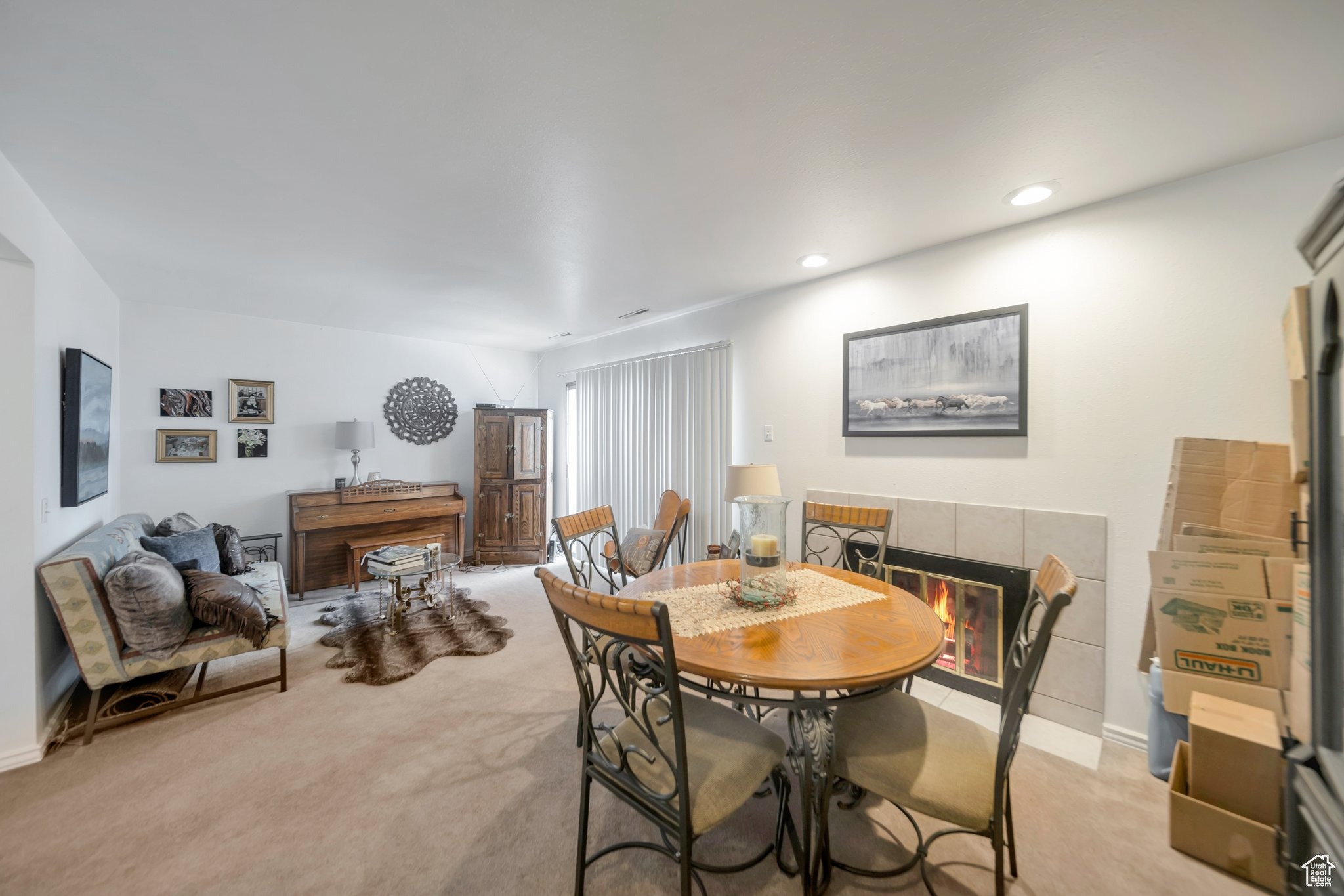 Dining space featuring light colored carpet and a tile fireplace