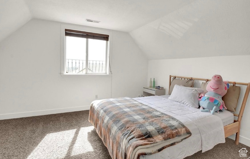 Bedroom featuring lofted ceiling and carpet floors