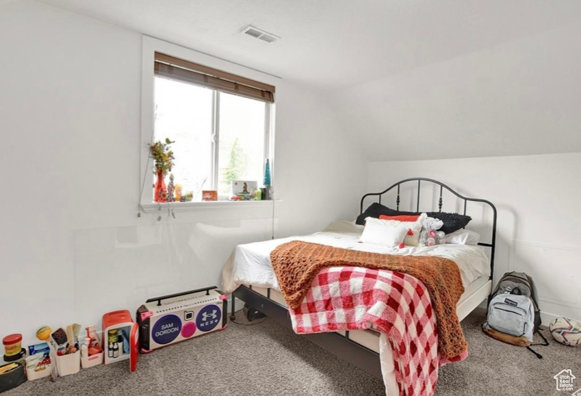 Bedroom featuring vaulted ceiling and carpet flooring