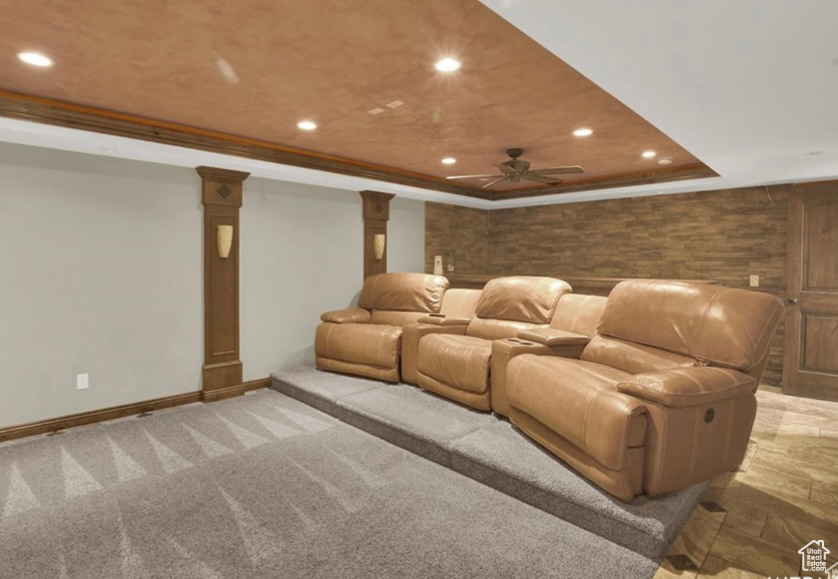 Cinema with crown molding, carpet flooring, a tray ceiling, and decorative columns