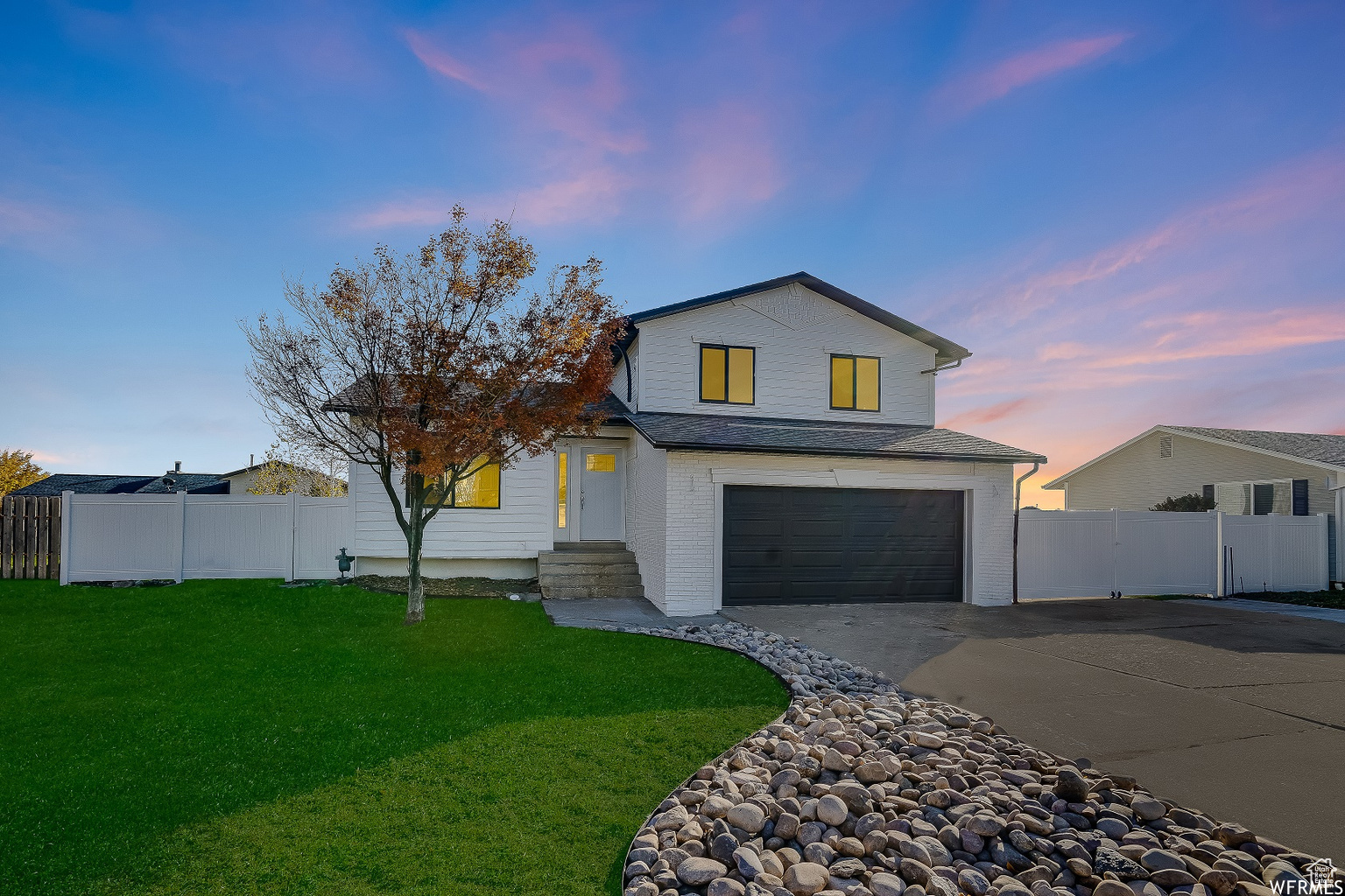 View of front of house featuring a garage and a lawn