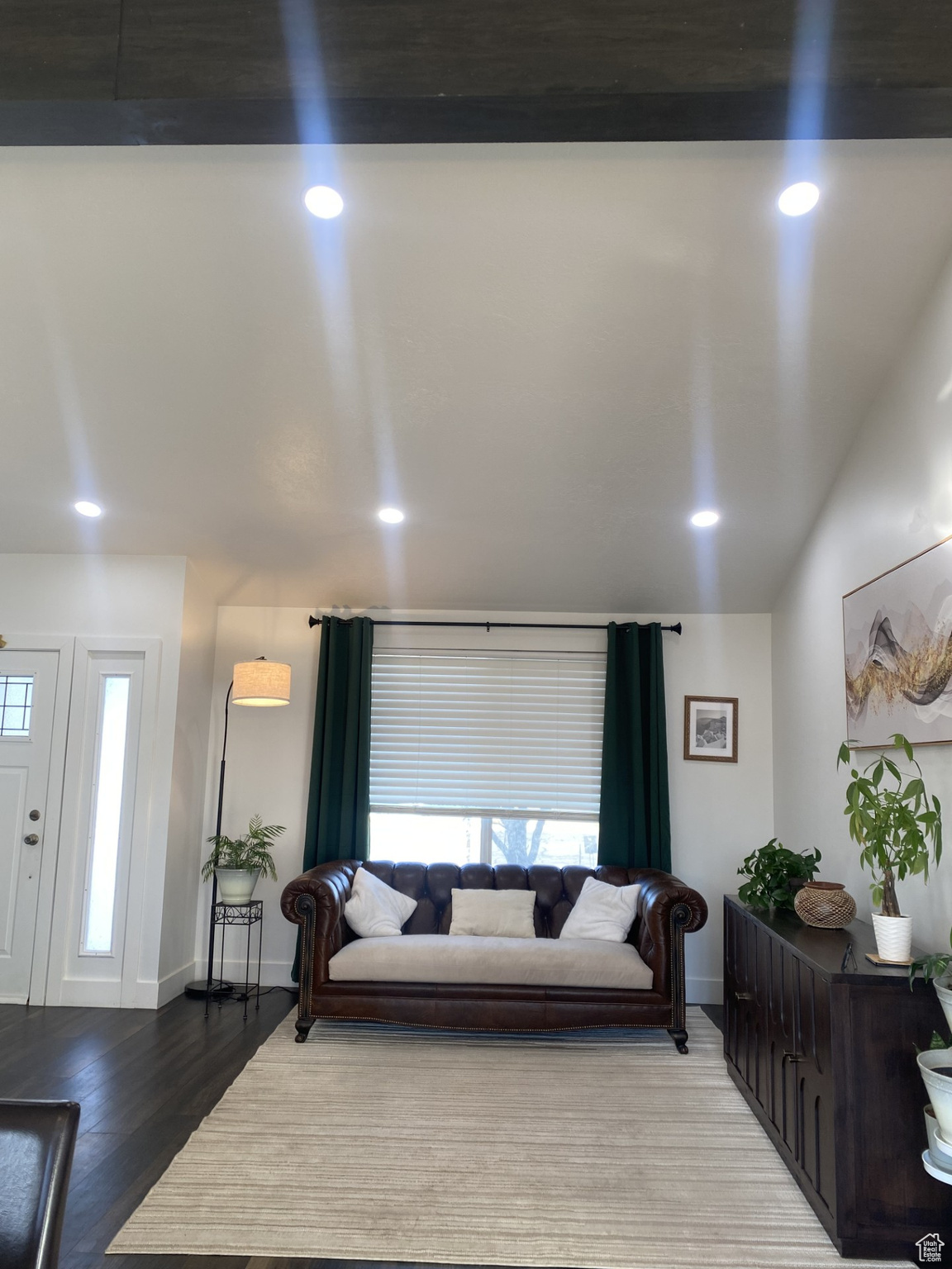 Living room with wood-type flooring and vaulted ceiling