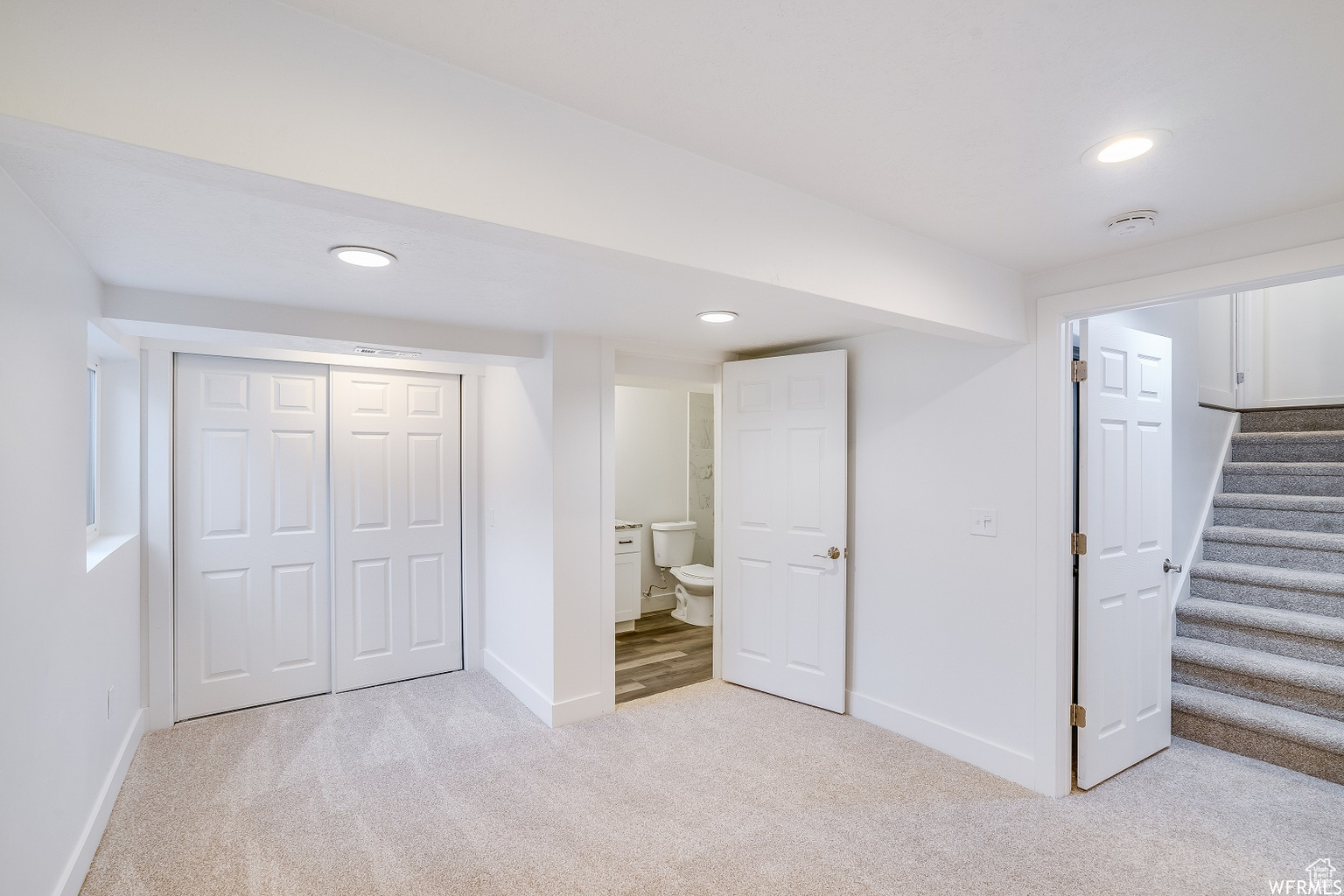 Basement featuring light colored carpet