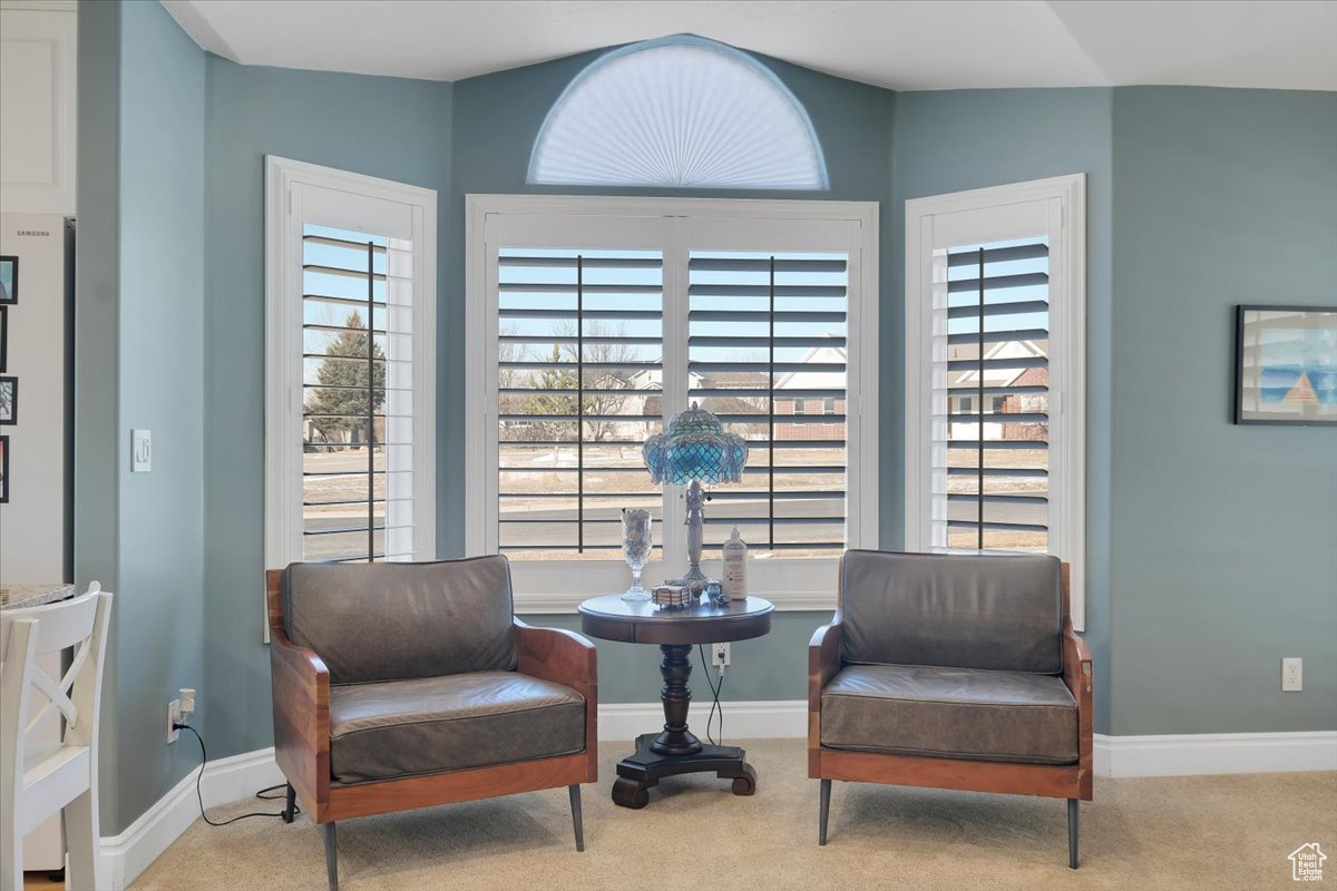 Sitting room with a wealth of natural light and light colored carpet