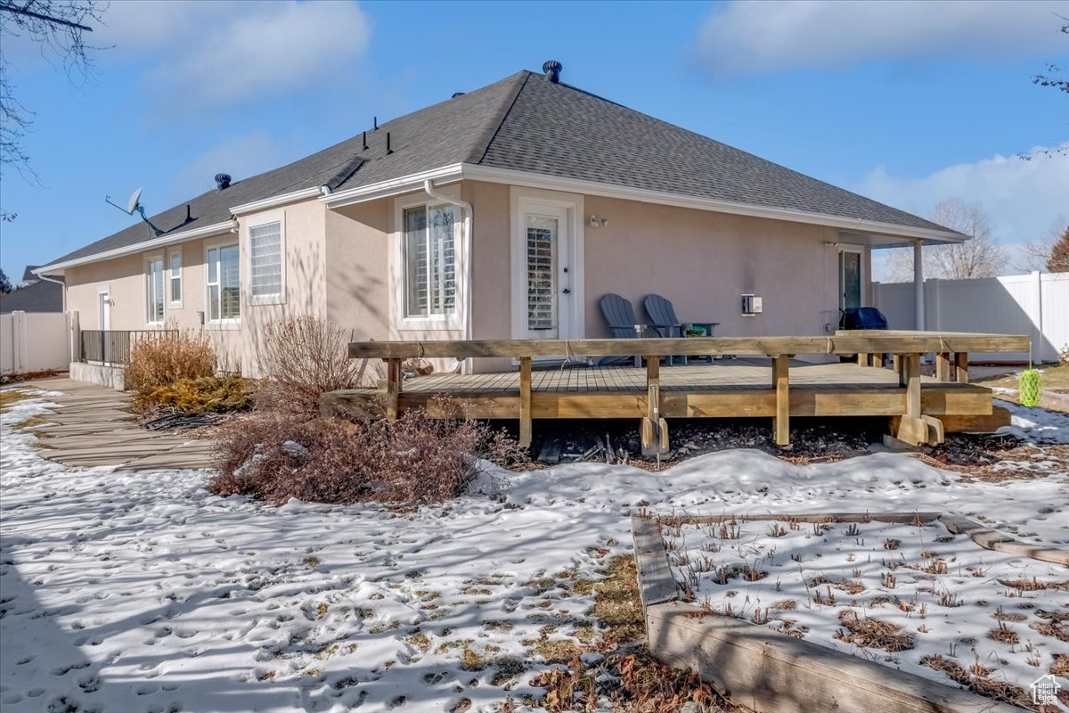 Snow covered property with a deck