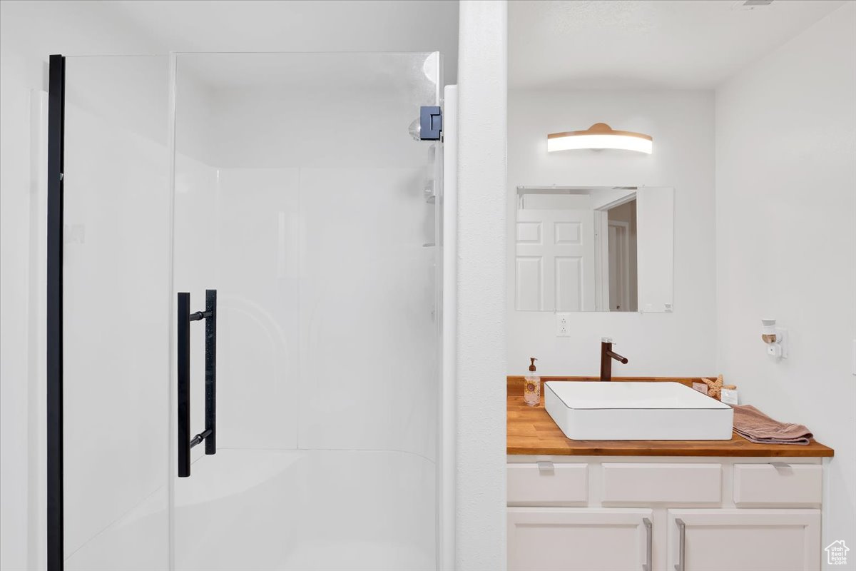 Bathroom with a shower with door and vanity