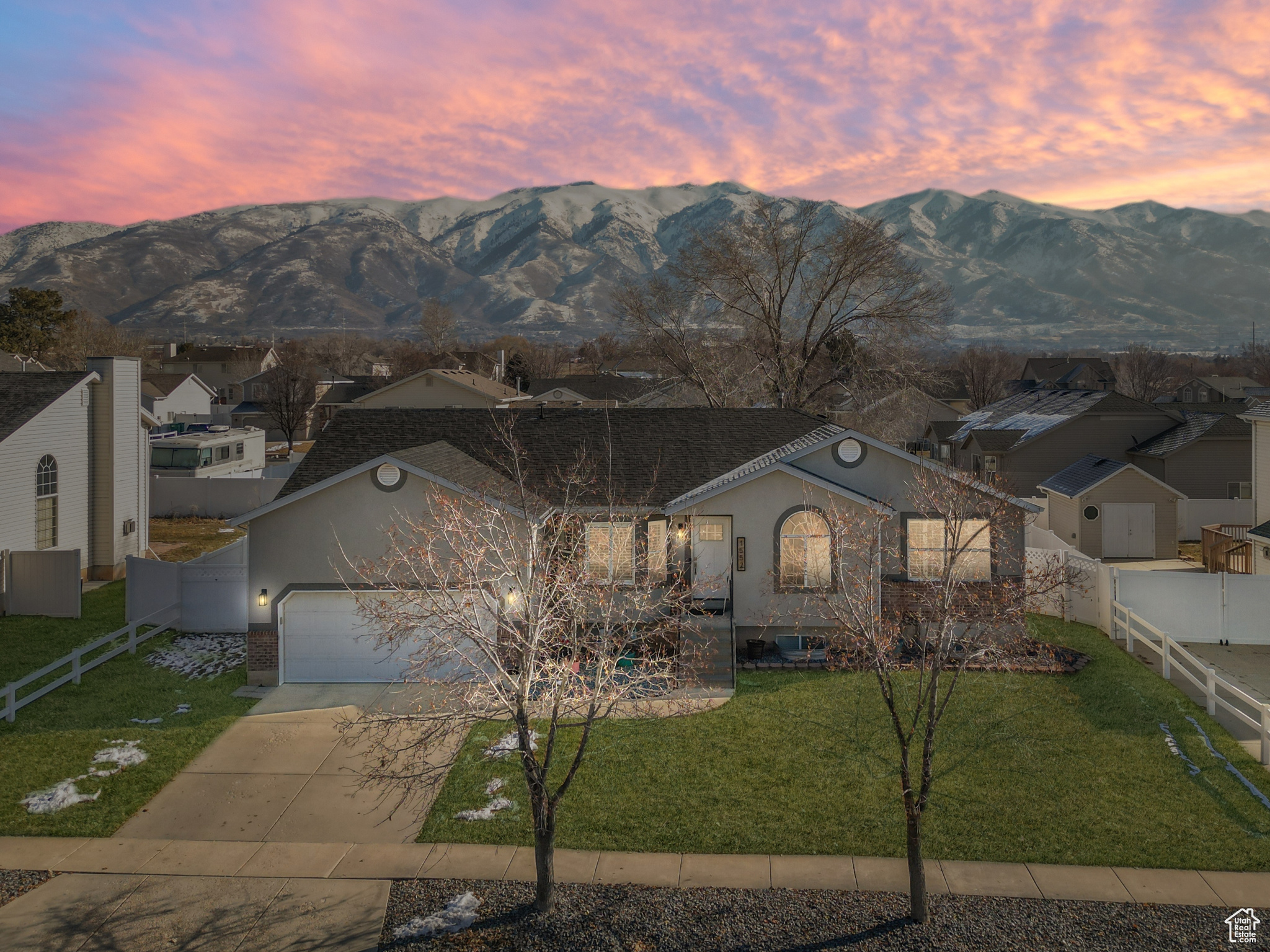 View of front of house featuring a mountain view, a garage, and a lawn