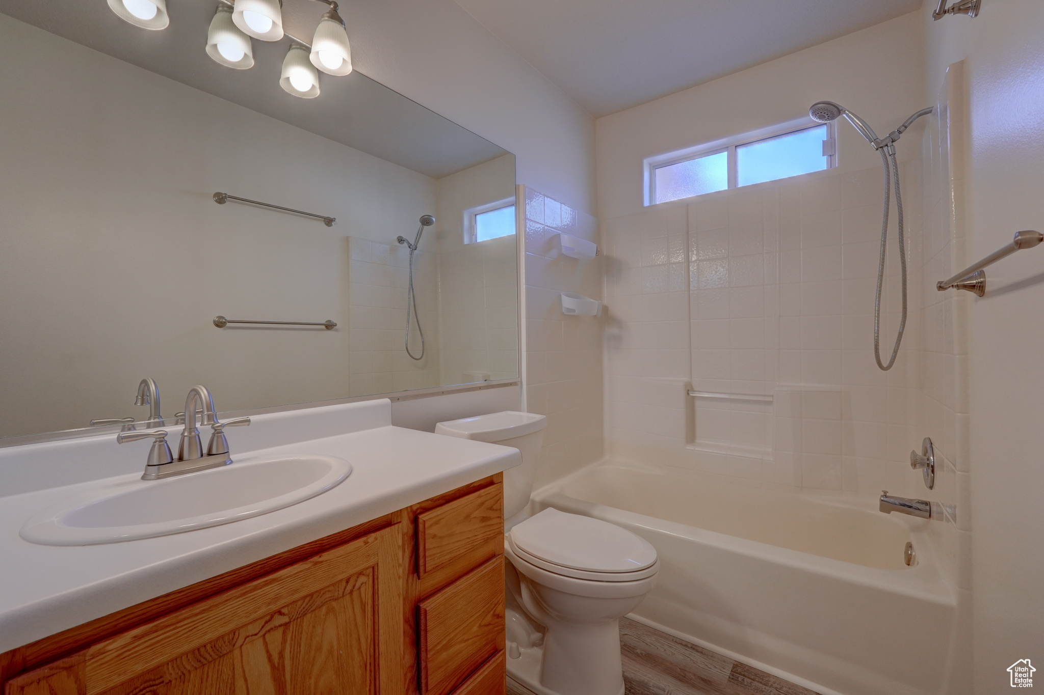 Full bathroom with hardwood / wood-style flooring, vanity, toilet, and shower / bath combination