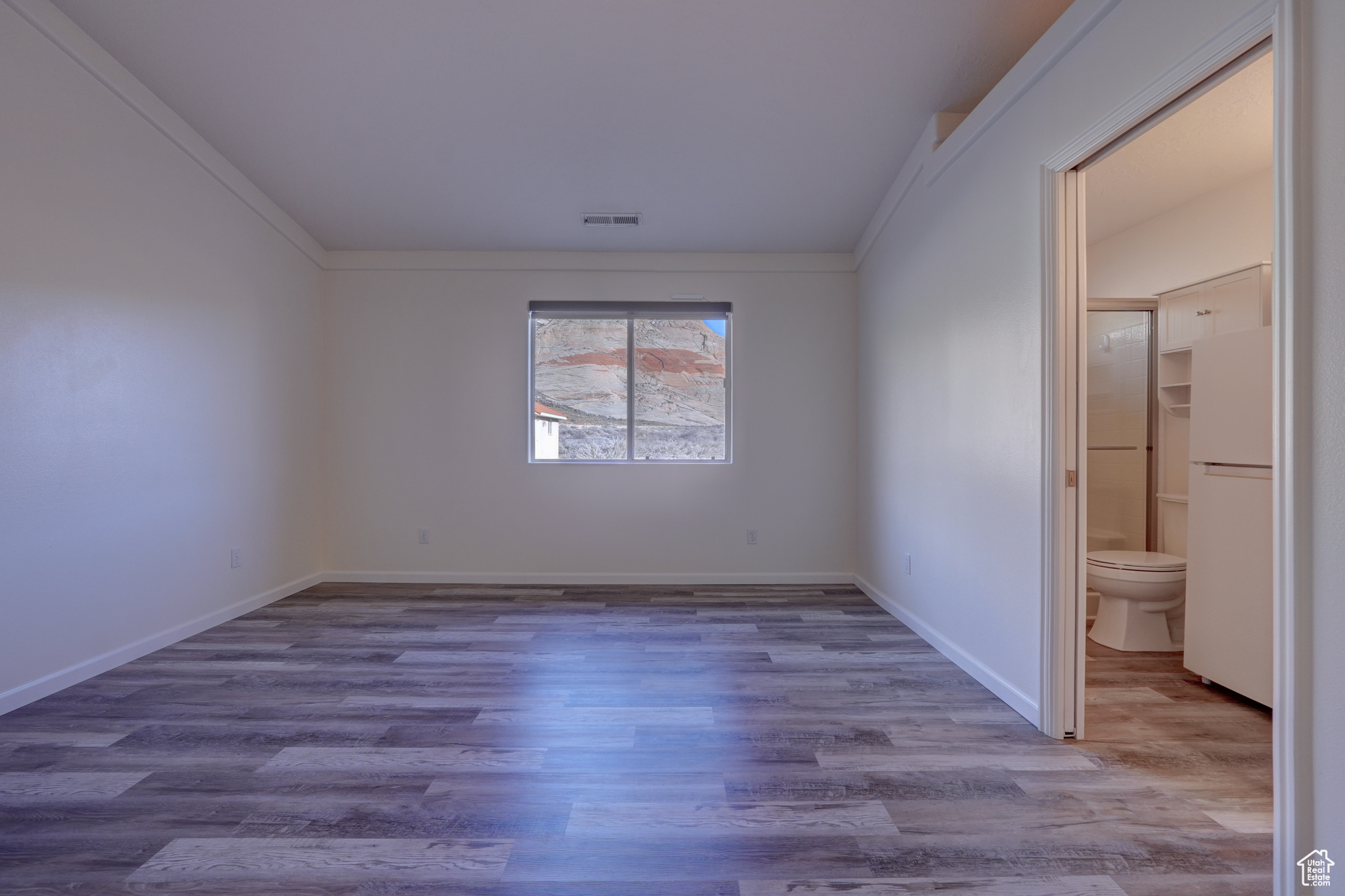 Spare room featuring crown molding and hardwood / wood-style flooring