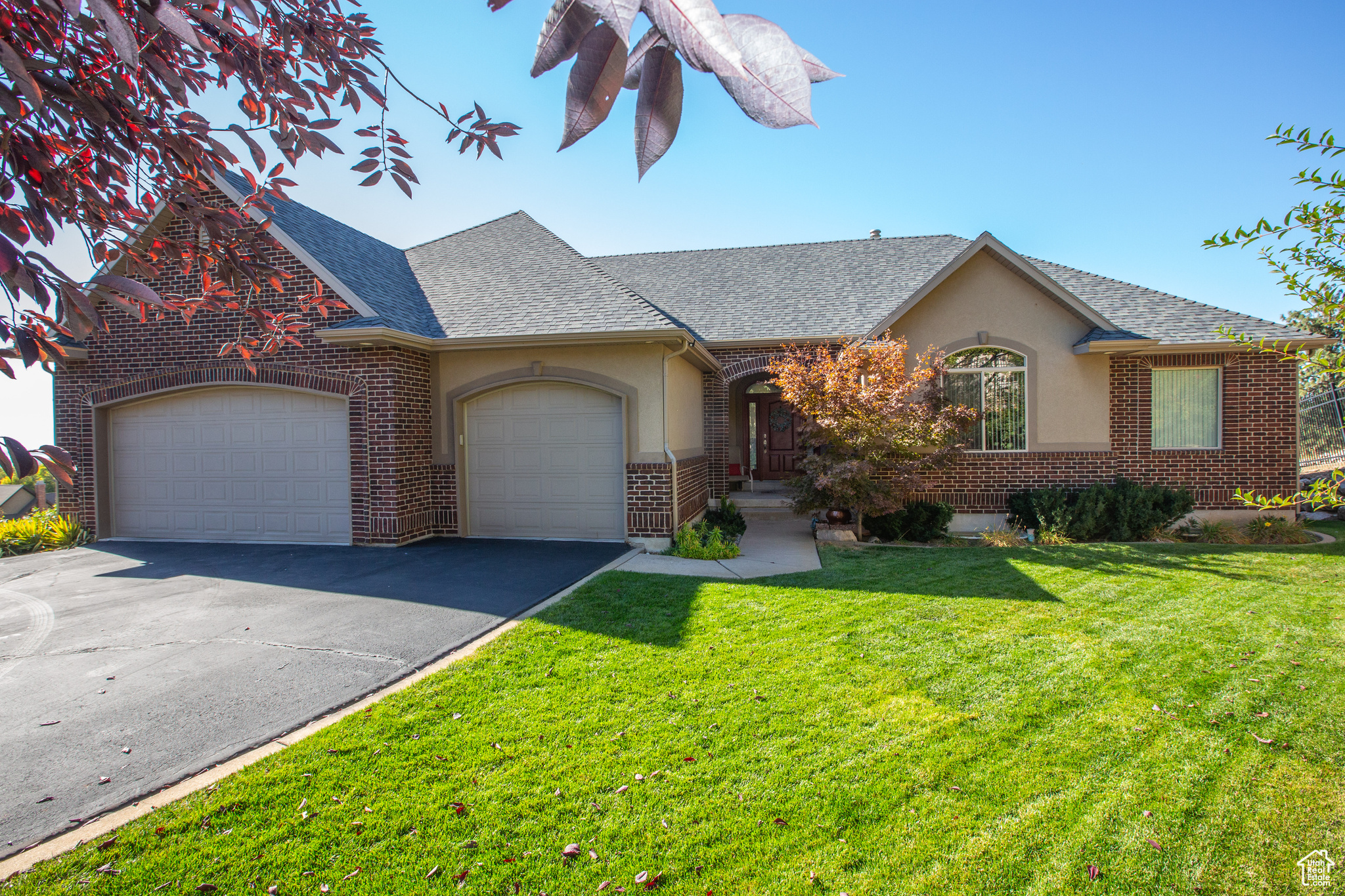 View of front of home with a garage and a front lawn